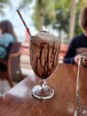 Taça de carfé com chantilly e caramelo, na mesa de uma lanchonete