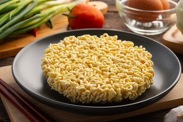 Close up Uncooked korean Instant noodles or dry noodles circle in black plate.