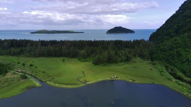 vegetations, cliff, lake and blue ocean with lush islands in the background at Geurute Beach