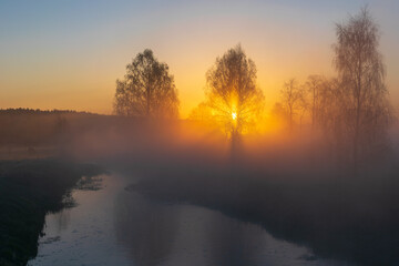 Fototapeta premium sunrise over the lake and field