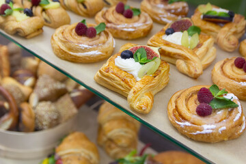 Delicious baking with berries and custard cream in glass showcase