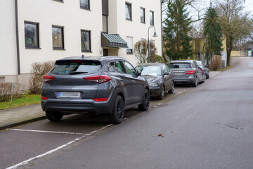 Parking situation on a quiet residential street featuring multiple parked vehicles in winter