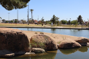 Bolders guarding water edge of Cortez park lake island, Phoenix, Arizona