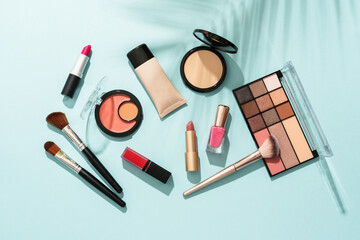 Beauty products for professional make up on blue background. Flat lay.