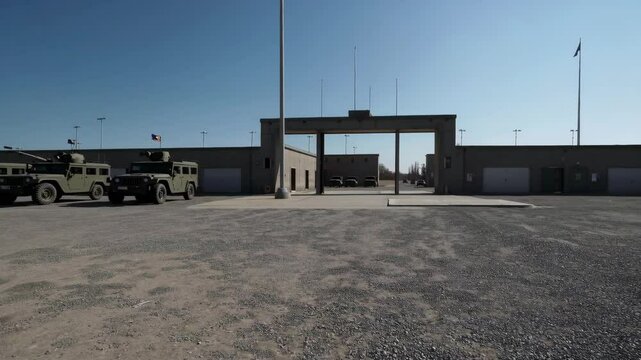 Empty Military Base with Vehicles Under Clear Blue Sky