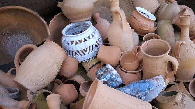 Close-up of clay products (vases, pots, etc.), including broken and cracked ones. Defective products of utensils, manufacturing defects.