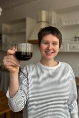 young modern woman drinking black americano coffee in the morning in the kitchen, enjoying the moment