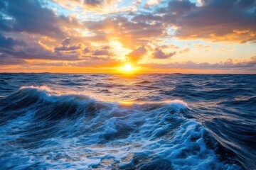 Obraz premium Sunset casts golden hues on rippling ocean waves under a vibrant sky, At sunset, the setting sun shines on the rippling wavelets of the sea