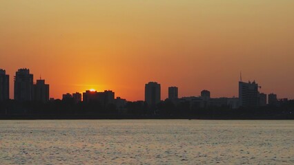 Experience the stunning beauty of a sunset reflecting over a vibrant urban skyline. Media