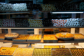 Colorful baklava shop window filled with golden, syrupy pastries.