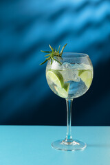 Cocktails gin and tonic with ice and lime slices on a blue background.