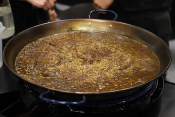 paella con arroz cocinándose en una paellera