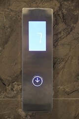 Elevator control panel showing floor number indicator with digits and up and down buttons. Modern...
