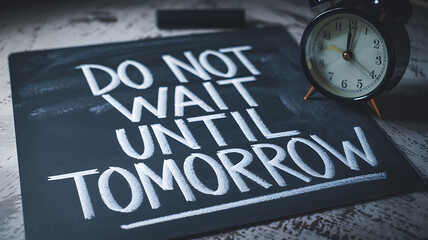 Fototapeta premium Chalkboard message Do not wait until tomorrow beside an alarm clock emphasizing urgency and seizing the present moment.