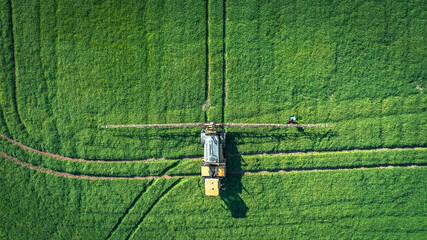 Tractor sprays fertilizer and water on a green fields of East Sussex, UK