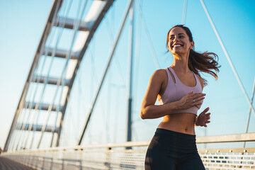 Happy Woman Jogging on a Modern Bridge During Sunrise Outdoors