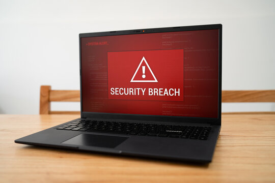 Security breach alert notification on laptop screen. Concept of hacking and online attack.