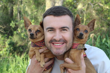 A handsome man and his small dogs 