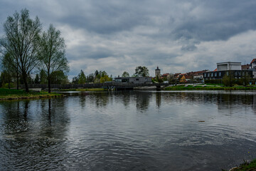 Fototapeta premium View of a city with a church behind a lake in a park