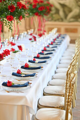 Grand reception table arrangement in artistic Italian villa with red floral accents, elegant tableware, and stunning historical ambiance with detailed ceiling frescoes