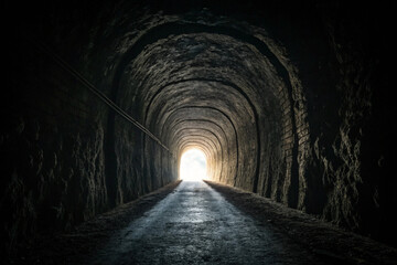Obraz premium A dark tunnel with one light at its end - generated by ai