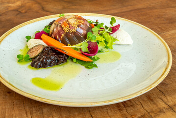 Gourmet appetizer with vegetables, jelly dome, and fresh greens
