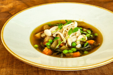 Vegetable soup with mushrooms and fresh peas
