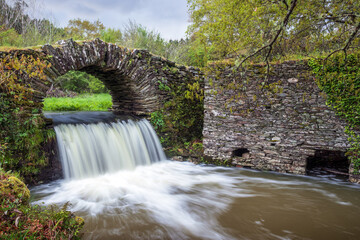 Waterfall with schist bridge and mill ruins in Meda de Mouros, Tábua, Portugal...