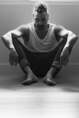 Obraz premium man on the floor of his house sitting in a tough attitude