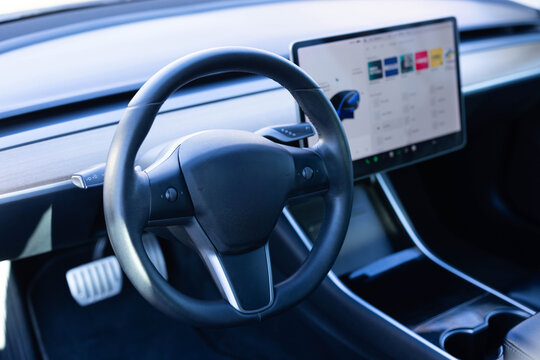 Steering wheel of electric vehicle, interior, cockpit, electric buttons. Autonomous car. Driverless car. Self-driving vehicle. Empty cockpit electric vehicle, Head Up Display and digital speedometer - Powered by Adobe