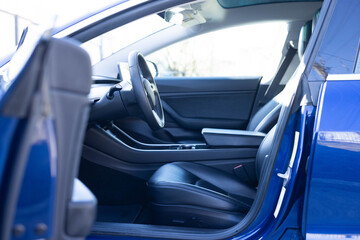 Car interior luxury inside. Steering wheel, dashboard, speedometer, display. Black leather...
