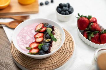 Presented by fruits putting yogurt toppings with strawberry, berry, oats, raisins and chia seed...