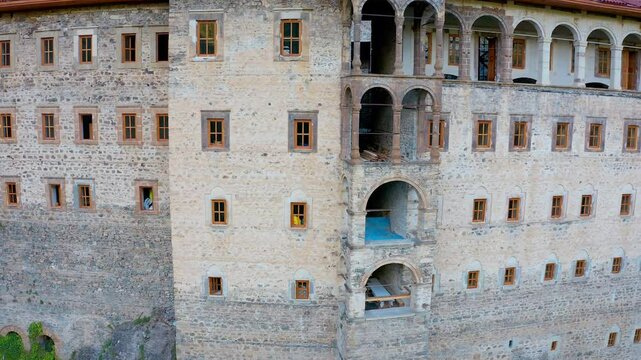 The impressive facade of the Sumela Monastery is captured by the drone's smooth receding motion. It appears that restoration work is ongoing.