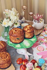 homemade easter cake with eggs. table with lots of confectionery decorations, cupcakes, and sweets