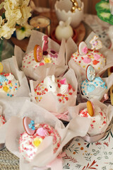 Easter table with Easter cakes decorated with white icing and confectioners decor.