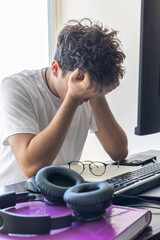 Stressed teenager with head in hands while studying at home. Distance learning, exam anxiety,...