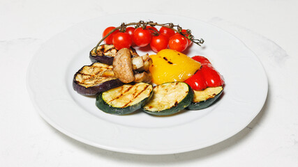 Grilled vegetables, barbecue. Fried eggplants, tomatoes, peppers and mushrooms on a white plate