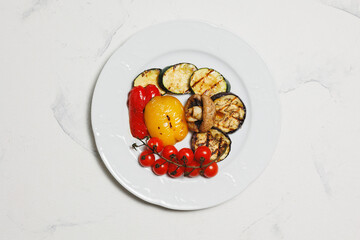 Grilled vegetables, barbecue. Fried eggplants, tomatoes, peppers and mushrooms on a white plate