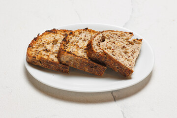 Sliced ​​whole grain bread on a white plate.