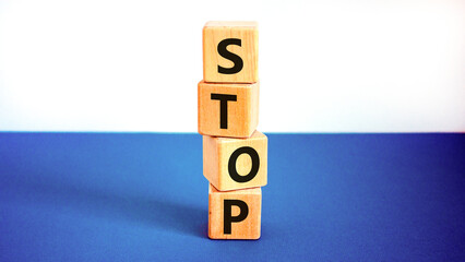 Stop symbol. Concept word Stop on beautiful wooden blocks. Beautiful white and blue background....