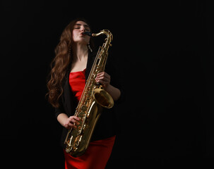 Obraz premium Professional musician playing saxophone on black background. Space for text