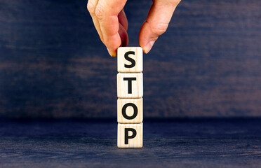 Stop symbol. Concept word Stop on beautiful wooden blocks. Businessman hand. Beautiful black table...