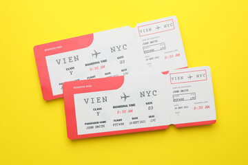 Travel agency. Flight tickets on yellow background, top view