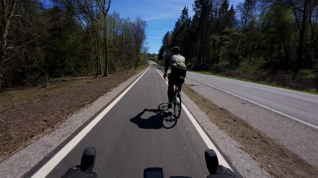 A man cycling on a new, smooth bike path in Bavaria, Germany. Safe and modern cycling infrastructure runs through scenic forest, offering perfect conditions for commuting and recreation
