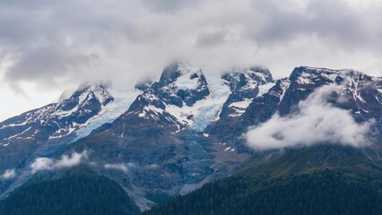 A picturesque mountainous landscape with clouds shrouding the summit, suggesting either a volcanic or tropical location.