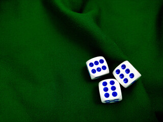three dice on green fabric background