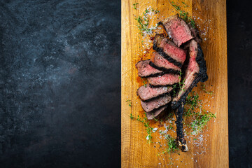 Traditional grilled barbecue dry aged tomahawk beef steak meat with salt and fresh herbs served and...