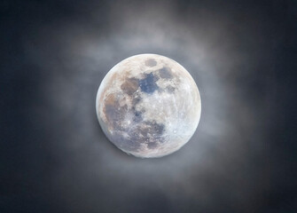 Full moon among the clouds. Full moon photographed with a telescope.