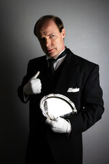 Butler or Hotel Concierge in Black Formal Suit and White Gloves Standing at Elegant Attention. Professional Hospitality and Service Industry