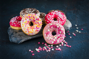 Traditional festive glazed doughnuts with icing sugar and chocolate decorated with colorful...